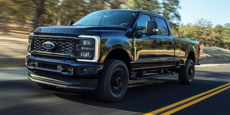 A black 2024 Ford F-250 driving down the highway